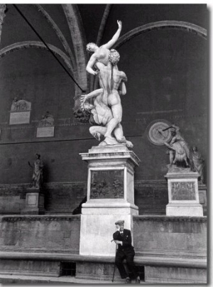 Man Sitting Beneath Statue