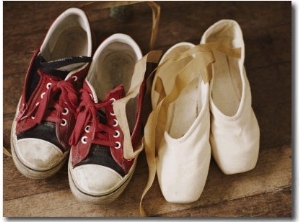 A Pair of Tennis Shoes with Red Laces Sits Next to a Pair of Ballet Slippers