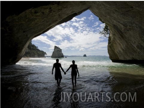 Couple Walking Through Water in a Sea Cave at Cathedral Cove Beach